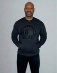 Man wearing an all-black Proud HBCU Grad sweatshirt featuring a hand-stitched chenille patch and front pockets, designed to celebrate HBCU pride and legacy