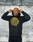 Model wearing a black Proud HBCU Grad hoodie with a handcrafted camo chenille patch, varsity-style stitched lettering.