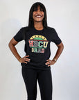 A good alt tWoman smiling and wearing a black t-shirt with the text 'Proud HBCU Grad' in colorful letters.