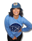 "Proud HBCU Grad sweater in North Carolina blue with a royal blue and white hand-stitched chenille patch, celebrating HBCU alumni pride."